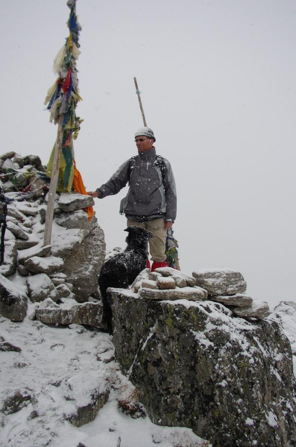 Jaap Hardy op het hoogste punt van de trekking (Laurebina Pas, 4610 meter) in een halve sneeuwstorm, met Tibetaanse gebedsvlaggen.